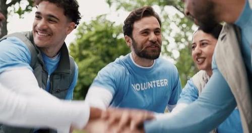 Smiling Volunteers Putting Hands Together in Park