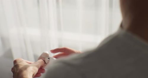 Close Up of Woman Inserting Wireless Headphones Into Her Ear