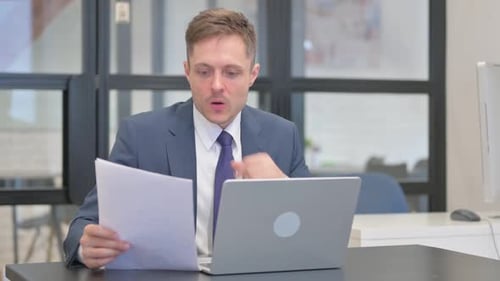 Stressed Businessman Working at Computer in Office