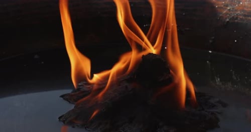 Flames flickering from a fire in a round bowl in Nepal.