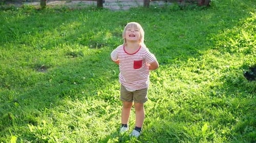 Funny Kid Boy Jumping in Park Outdoor Little Toddler Playing on a Lawn on Green Grass Small Child