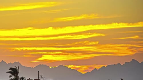 Burning red clouds in the sky above a mountain