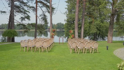 Outdoor Wedding Ceremony Setup with Chairs and Floral Arch