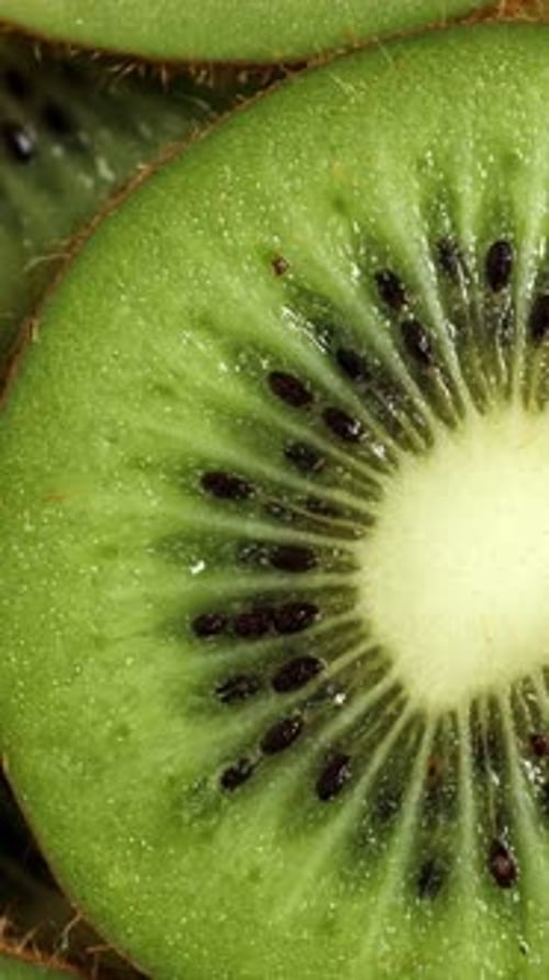 A Lot of Sliced Kiwi Rotating Ripe Tropical Fruits Closeup Vertical