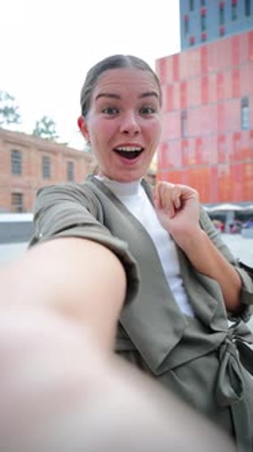 Smiling Woman Waving Hello Outside in City