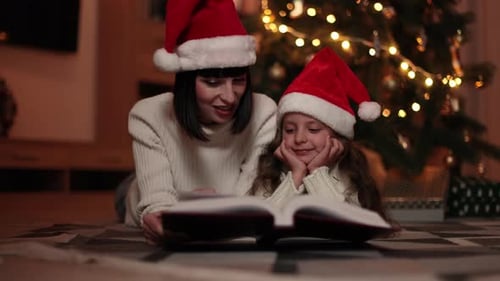 Mother and Daughter Reading Christmas Book Together