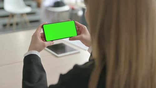 Close Up of Young Businesswoman Watching Smartphone with Green Screen