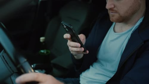 Man in Car Looking at His Smartphone