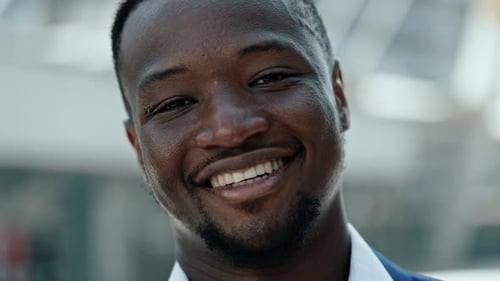 Closeup Portrait of Young African American Businessman Smiles on City Street
