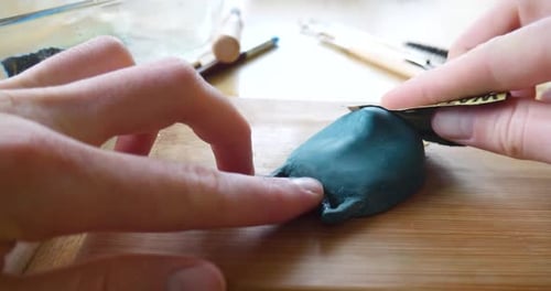 Close up Hands Sculpting Small Object with Dark Blue Polymer Clay