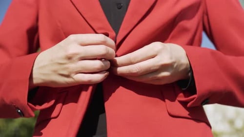 A Businesswoman in a Suit Buttons Up Her Jacket Closeup