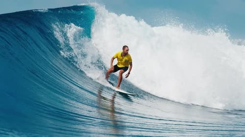 Wave Surfing Man Surfs the Wave in the Maldives