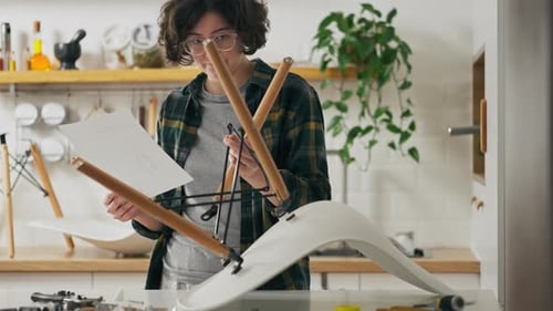 Jeune femme seule, concentrée, étudiant les instructions de montage des meubles pendant le montage
