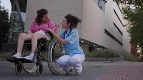 Healthcare Worker Talking to Woman in Wheelchair