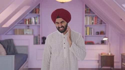 Man Rubbing Neck in Discomfort Indoors