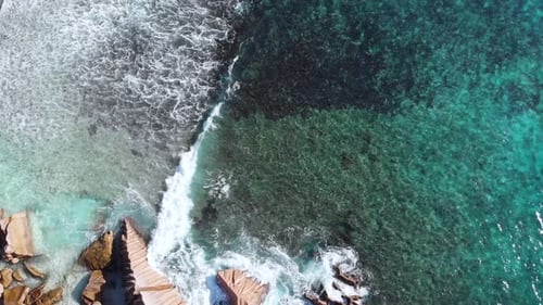 Where land meets the sea. This is an aerial view of waves breaking on the rocks and white beaches at