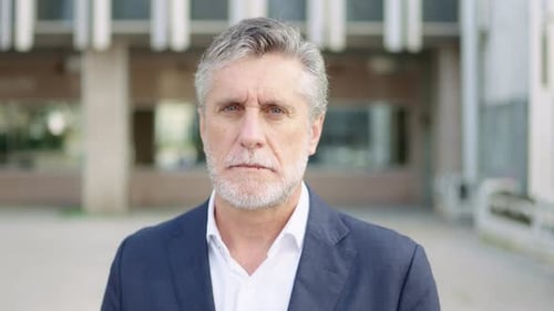 Man in Blazer Smiling Outside Office Building