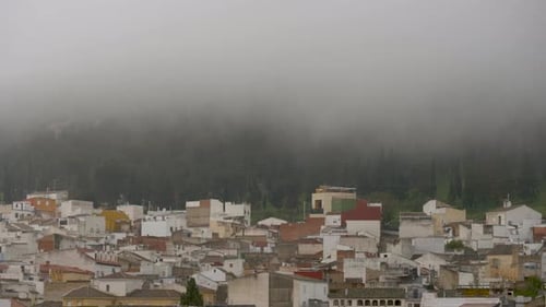 humble houses on the side of a mountain surrounded by fog