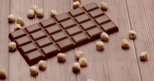 Milk Chocolate Bar With Whole Hazelnuts on Wooden Surface