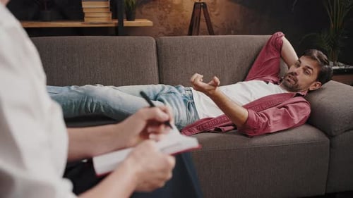 Man Talking to Therapist on Couch Indoors