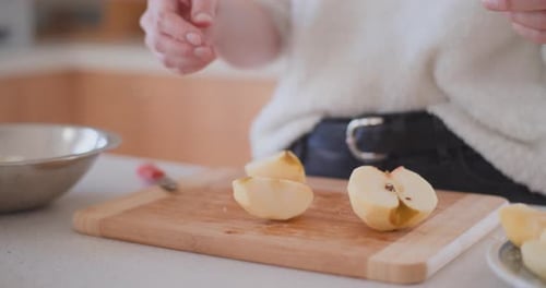 Woman Cutting Apples in Kitchen at Home