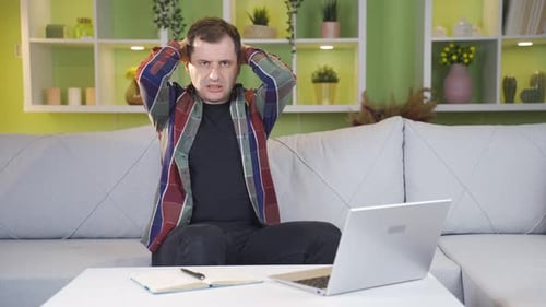 Frustrated Man Working from Home on Laptop
