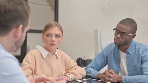 Close up of Woman Talking with Multi Ethnic Teammates