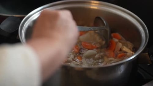 A woman's hand making pork soup