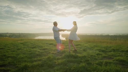 Lovers Spinning Lovingly on Grassy Hill at Sunset By Serene Lake