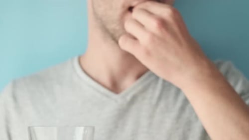 Adult Man Taking Pill with Water Close Up
