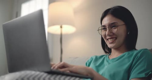 Woman Smiling Using Laptop at Home