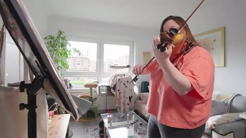 Woman Practices Violin at Home