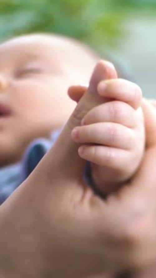 Sleeping Infant Holding Onto Finger Peacefully