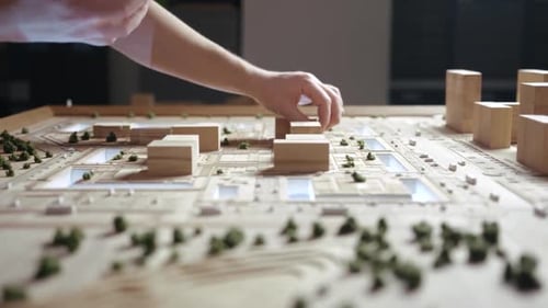 Hands of Professional Man Constructing Architecture Model of Urban City Building