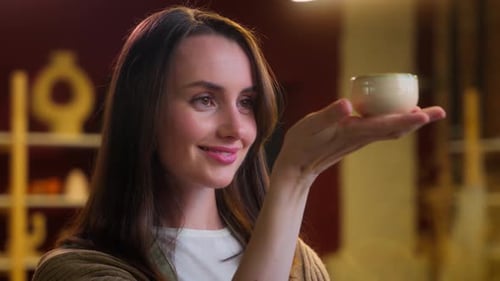Woman Inspecting Handmade Ceramic Bowl in Workshop