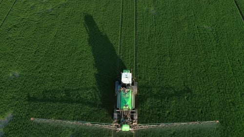 Farming Tractor Crop Sprayer on Green Field