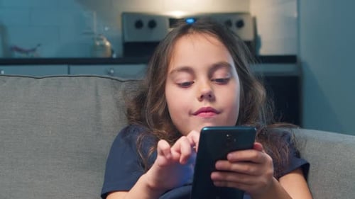 Young Girl Using Mobile Phone at Home