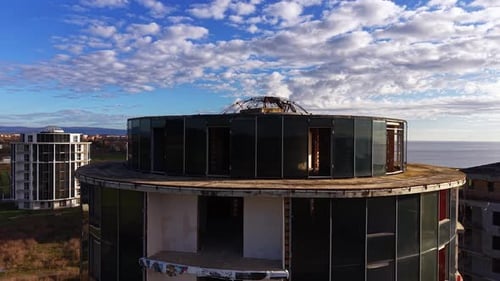 Diseño cónico del edificio de gran altura con cúpula de barras de refuerzo de metal en la parte superior.