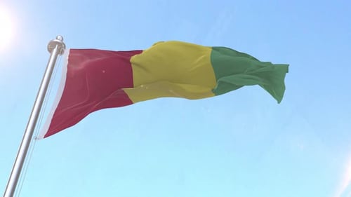 Guinea National Flag Waving in Wind Against Blue Sky