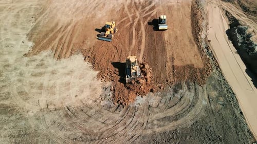 Construction Bulldozers Leveling Dirt from Aerial View