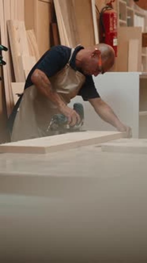 Professional Carpenter Cutting Wooden Plank with Jigsaw in a Workshop