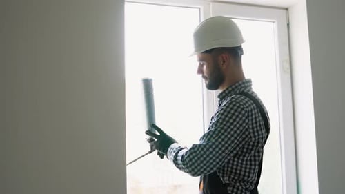 Construction Worker Caulking Window Frame
