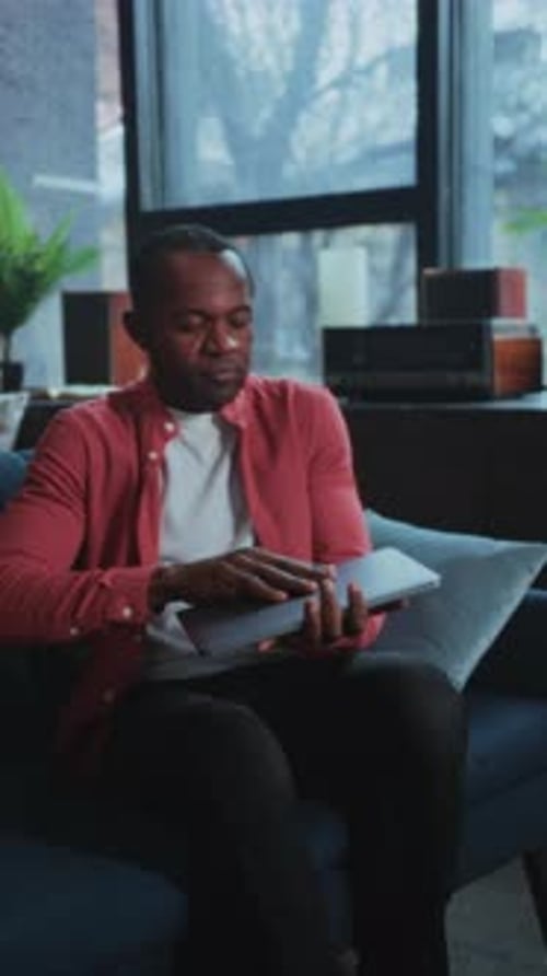 Focused Workspace Activity Professional Reviewing Documents and Typing in Contemporary Living Area