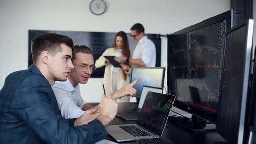 Team of stockbrokers works together in modern office at daytime