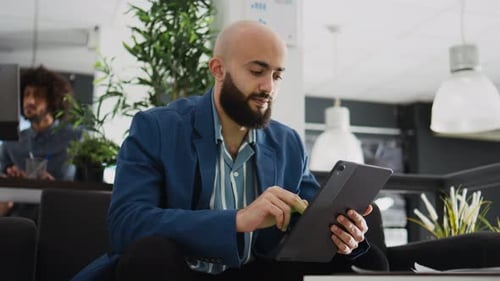 Young Adult Man Using Tablet in Modern Office