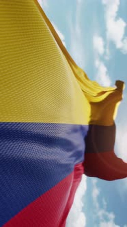 Realistic Waving Flag of Colombia in Blue Sky