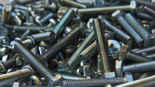 Stapel silberfarbener verchromter Metallschrauben zum Drehen auf einem Tisch 4