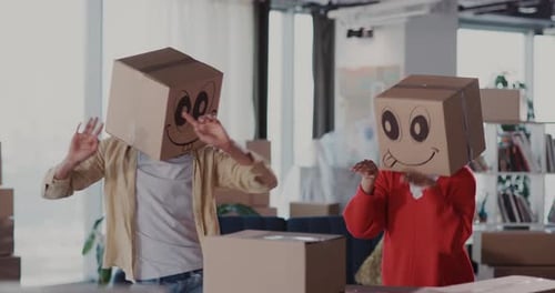 Casual Carefree Happy Dating Couple of Man with Woman Wearing Carton Boxes on Heads with Faces