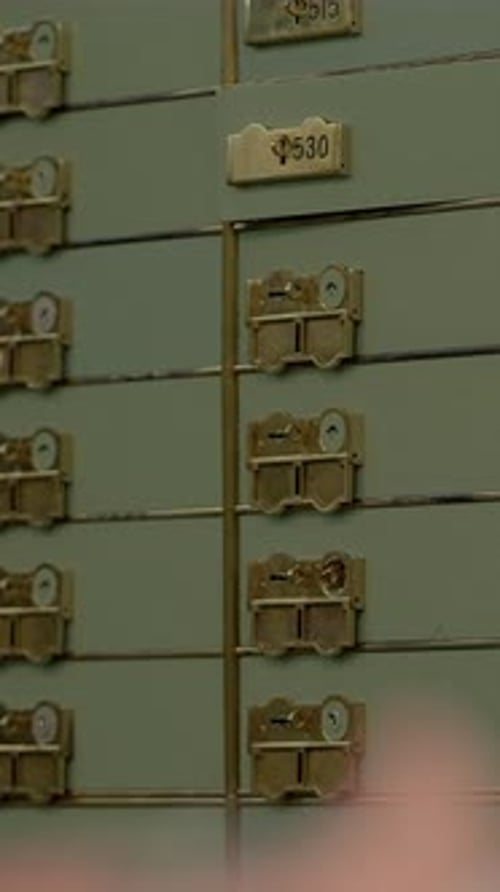 Hand Holds Keys near Safety Deposit Boxes