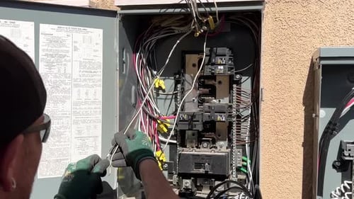 Eletricista trabalhando em linhas de energia na caixa de circuito após a instalação de painéis solares